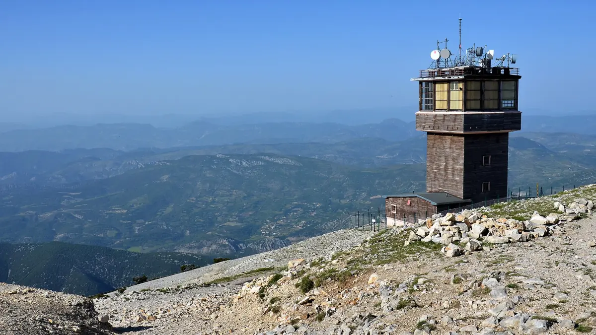 Weather station tower on the Mont Ventoux summit above distant hazy ridges